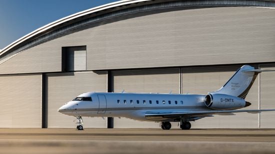 A Bombardier Global 5000 parked in front of a hangar
