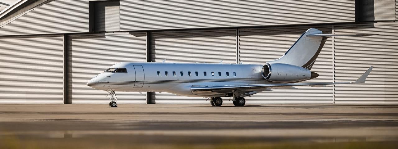 Private jet on parked in front of a warehouse. 